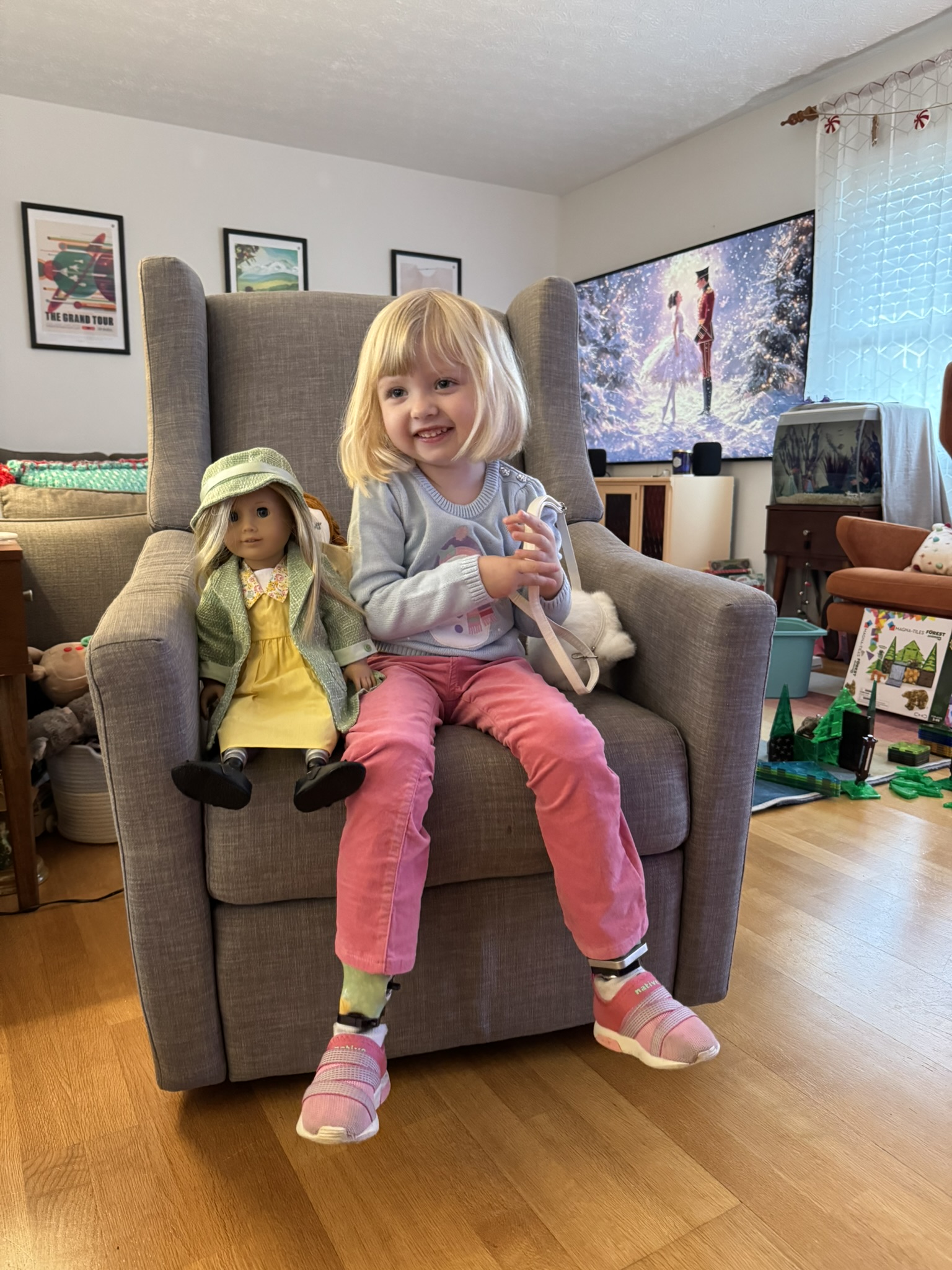 Gwen smiling while holding her American Girl doll with a custom prosthetic leg from A Step Ahead Prosthetics