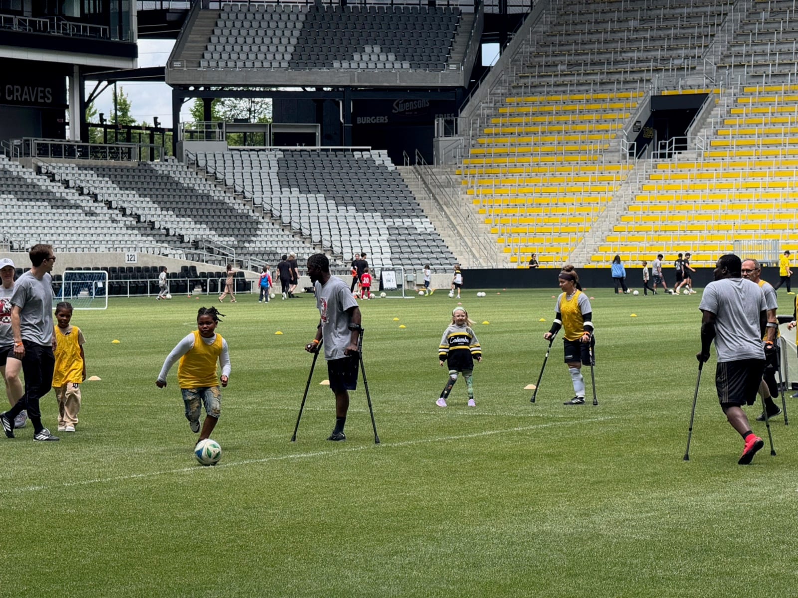 Gwen practicing soccer skills on the field alongside adult players from GOAT Soccer